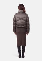 Graue Daunenjacke mit hochgeschlossenen Ärmeln, langer Wickelrock und schwarze Stiefeletten.
