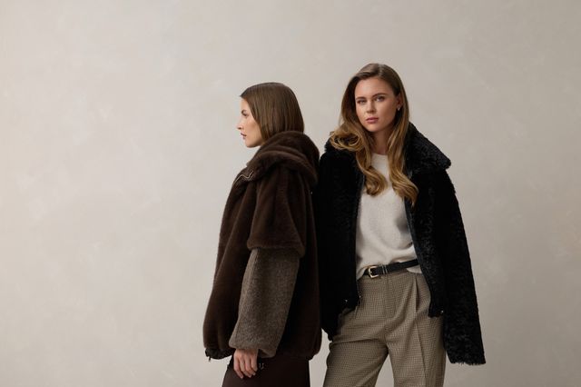 Zwei Personen in stylischen Winteroutfits mit Jacken und unterschiedlichen Hosen, Blick nach vorne.